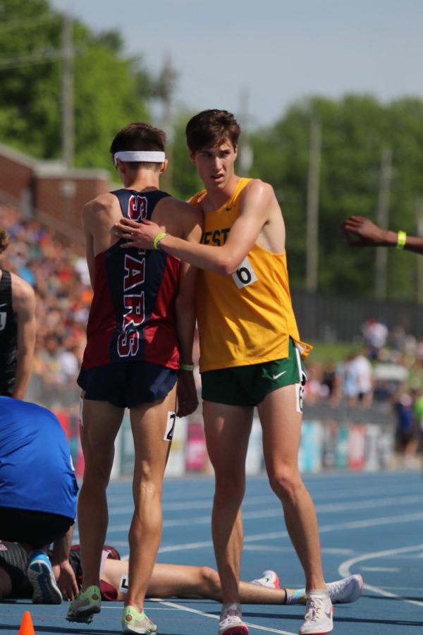 Senior Alex McKane (5th place) congratulates William Lohr of Sioux City North (6th place) after finishing the 3,200 meter run.