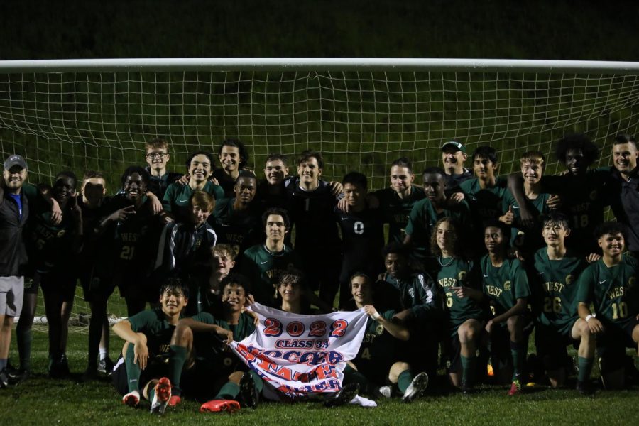 The boys soccer team poses with the 2022 state qualifier banner after beating Cedar Falls 6-1.