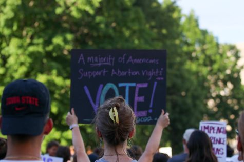 A protester holds up a sign urging people to vote during the protests on June 24, 2022. 