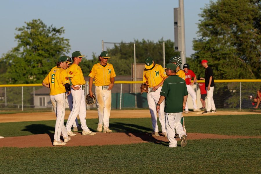 Coach Jesse Searls gives the starters a pep talk during a time out in the first inning of the second game against Cedar Falls on June 17, 2022. 