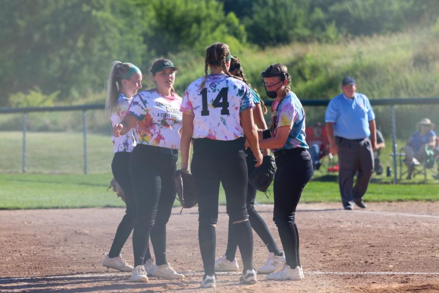 The softball team meets for a time out during the double header against City High on June 22, 2022. 