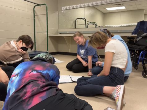 Kaylee Gibson (center) holds a props meeting  a month after her diagnosis of FND. When FND caused arm and hand weakness, she struggled to play her instruments. “ I had my dad hold [my trumpet] up, and I tried playing it and my muscle memory took over and I was able to play without a problem.” 
