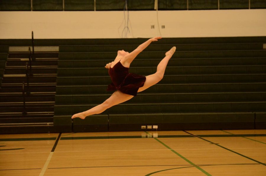 Paige Albright 23 leaps into the air during her solo.