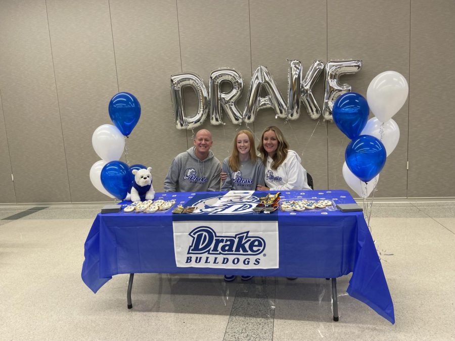 Camille Gretter 23 poses for a photo with her parents in the West High cafeteria Nov. 9 after signing her National Letter of Intent to row at Drake University.