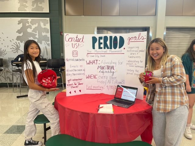 Cindy Wang 24 and Ijin Shim 24 pose in front of their sign at the club fair
