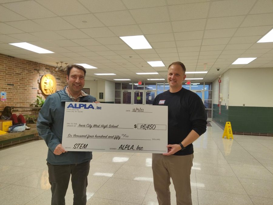 Dominic Audia and Keith Kraeplin stand holding a check for grant money.
