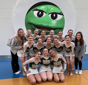 The team and their coaches, Kayla Drow and Maddy Floss 18, pose in front after competing their pom routine.