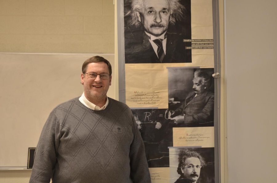 James Kirpes stands by a poster of Albert Einstein. His favorite quote by Einstein is, “Do not worry about your difficulties in Mathematics. I can assure you mine are still greater.”         