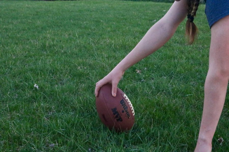A girl prepares to snap the football.