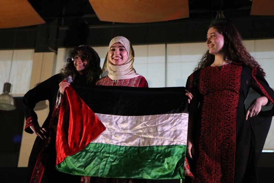 Jinann Abudagga 25, Shahd Suleiman 26 and Rana Saba 25 represent Middle East by posing with a Palestinian flag at Walk It Out.