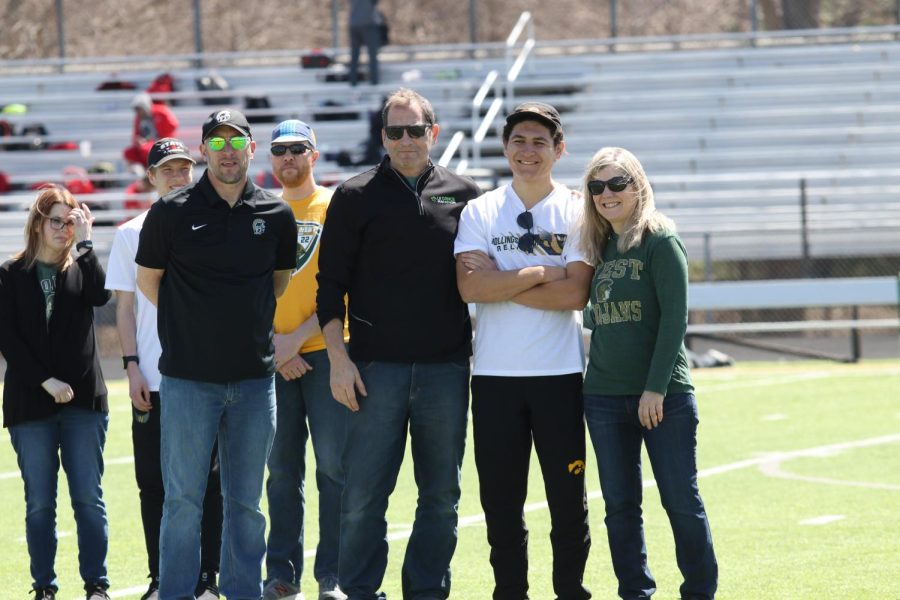 Coach Travis Craig poses with James Dickens 23 and his family during senior recognition, held between events on Apr. 8, 2023. 