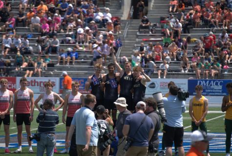 The shuttle hurdle team celebrates their win on the podium after the finals. 