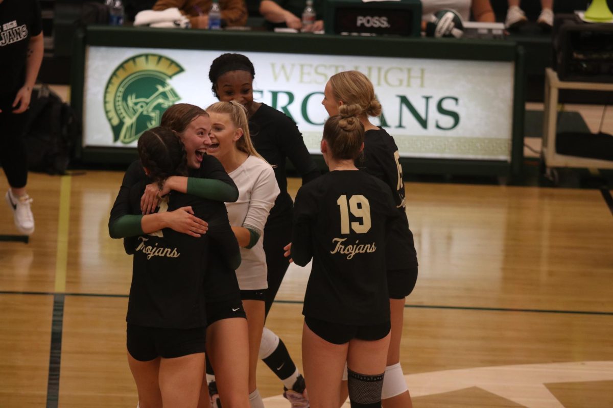 The+Trojan+team+celebrates+after+Elle+Barnett25+digs+up+a+ball+against+Western+Dubuque.