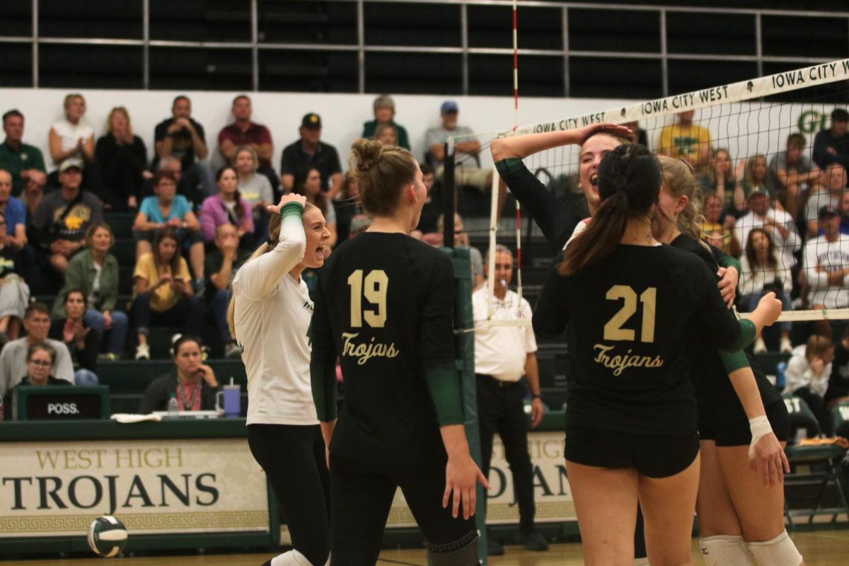 The Trojans huddle after scoring a point against Kennedy Sept. 26.