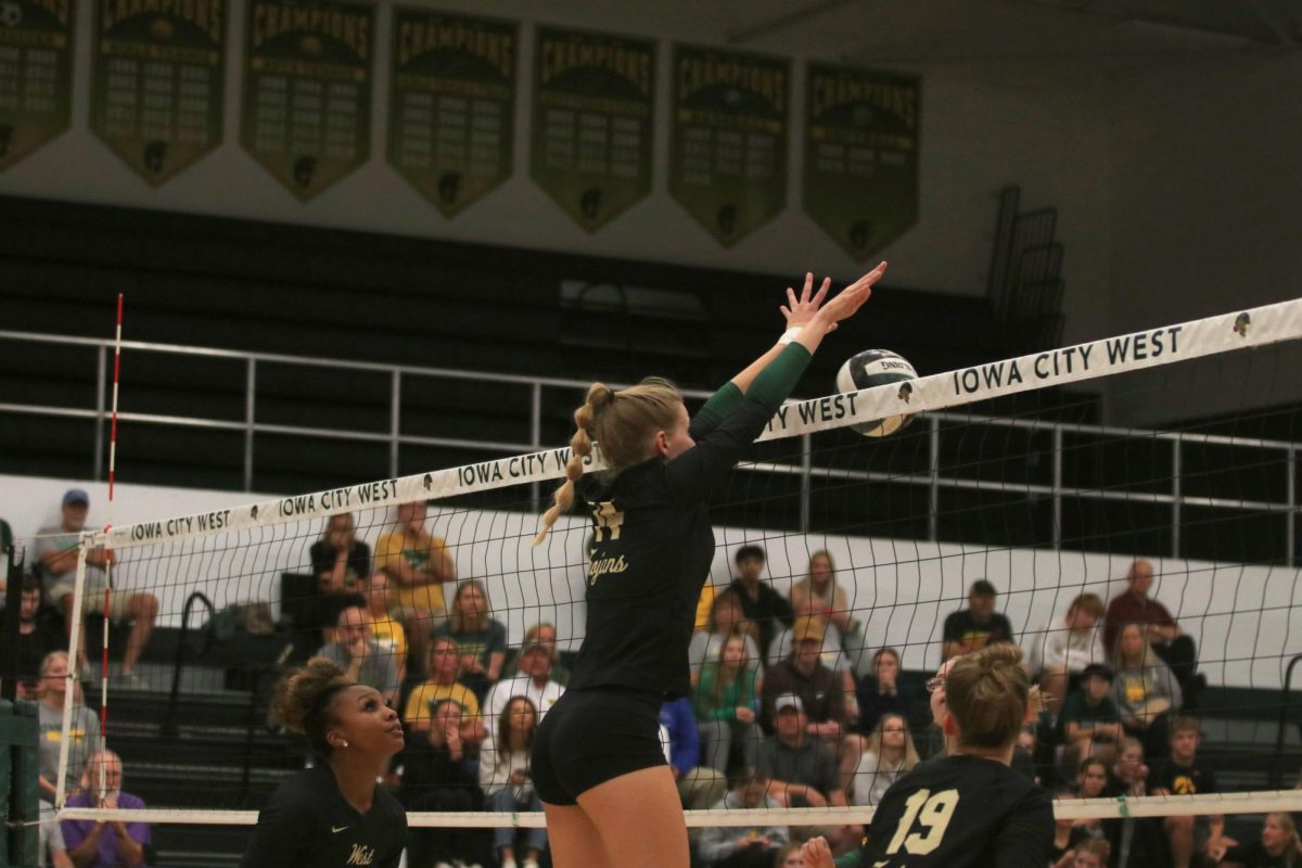 Senior Jocelyn Jacobsen reaches over the net to block during a point against Kennedy. 