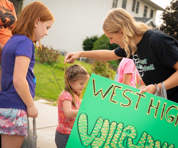 Sophie Bodin '25 hands out beaded necklaces to the crowd in the parade.