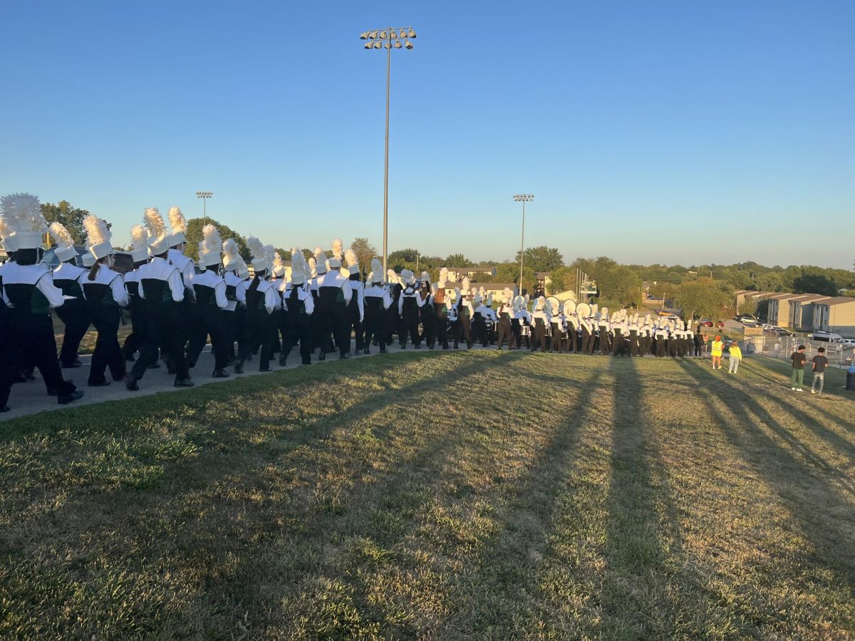 The Trojan Marching Band marches down to the West High football stadium to the beat of cadences from the West High Drumline.