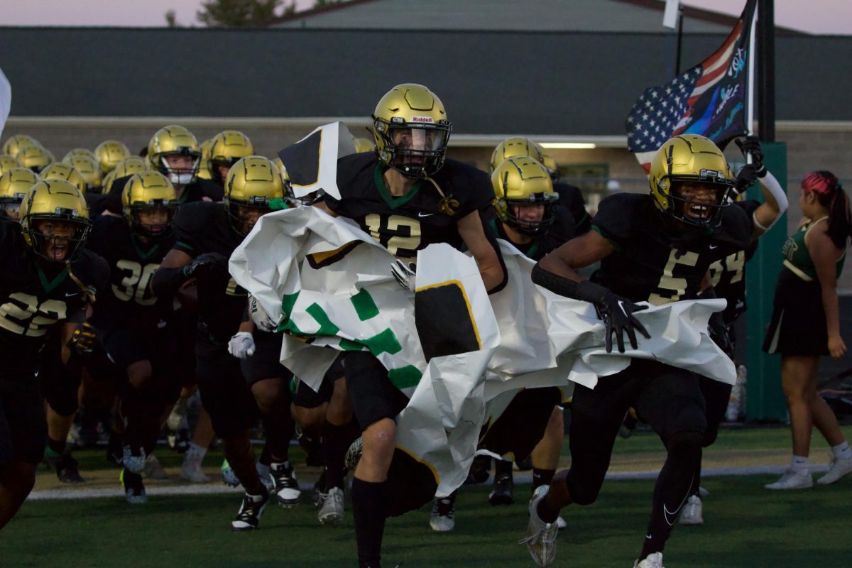 The Trojan football team runs out to the field Sept. 8 against Muscatine. 
