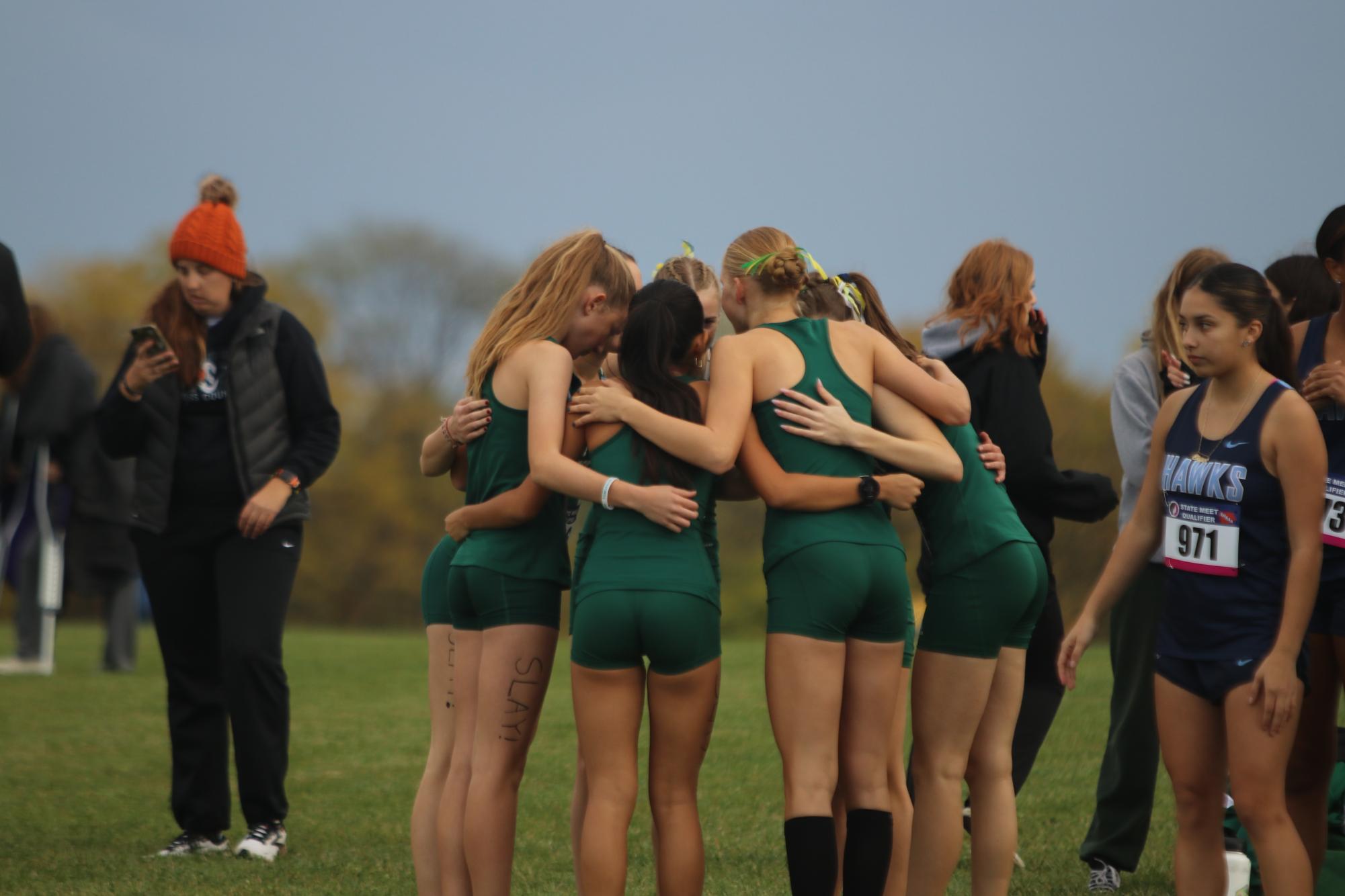The girls varsity team huddle together one minute before the starting of the race. 
