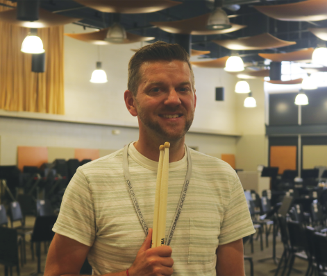 Brian Zeglis poses with drumsticks in the band room.