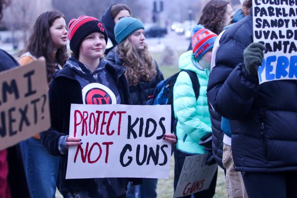 A City High student hold up a sign that reads Protect kids not guns at the protest on Jan. 8, 2024. 