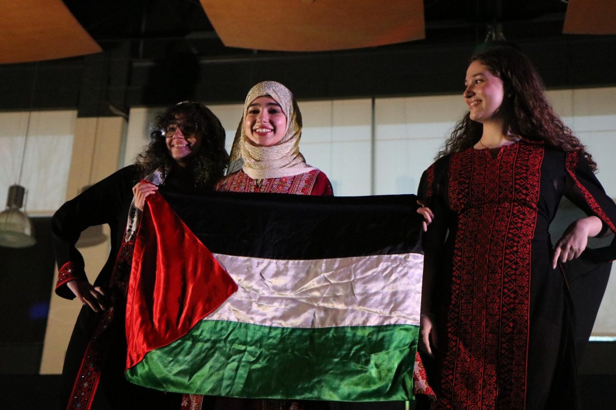 Jinann Abudagga 25, Shahd Suleiman 26 and Rana Saba 25 raise the flag of Palestine during Walk it Out 2023