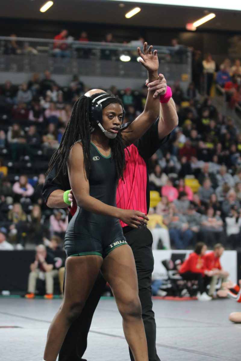 The referee holds up Trinity Myers 25 hand after she wins her second round in the state tourament. 
