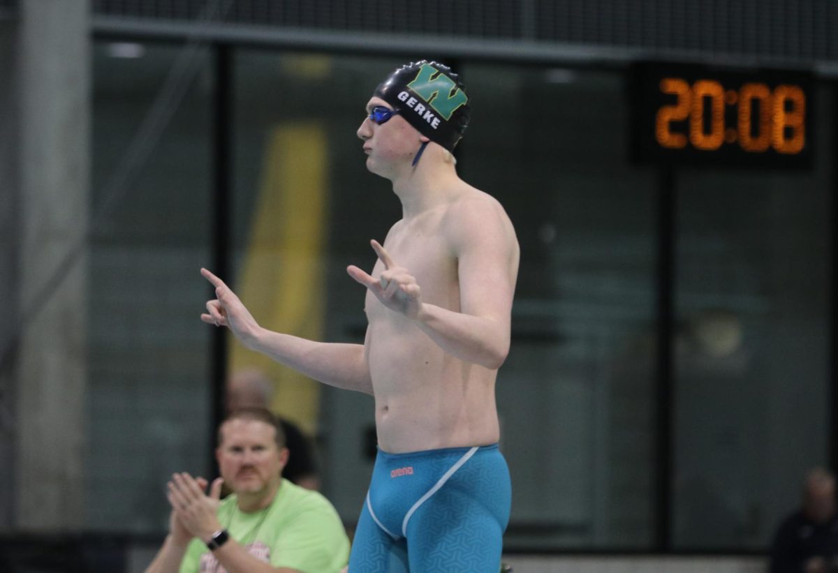 Max Gerke 24 holds up the peace sign before the 100-yard Butterfly at the IHSAA State Championships Feb. 9. 