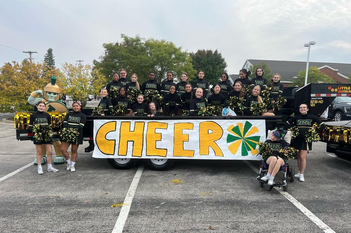 West+High+cheer+team+poses+in+front+of+their+float+at+the+annual+homecoming+parade.+