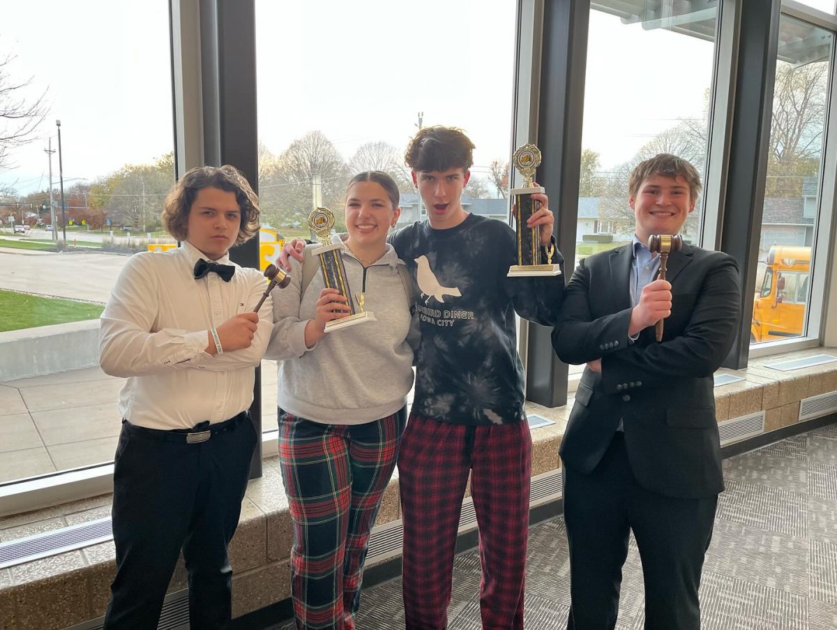 Endrit Ramku ’27, Finnley Bonfig ’26, Lincoln Beihl ’25 and Rowan Bihun ’26 pose with their trophies after competing in Congressional Debate at the Bettendorf Bulldog Invitational Nov. 10-11.