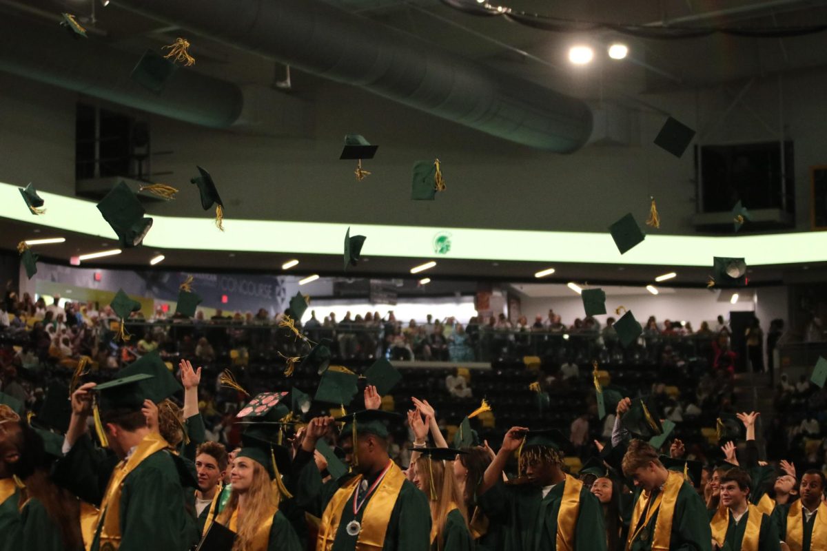 Students throw their graduation caps into their air at the end of the ceremony.