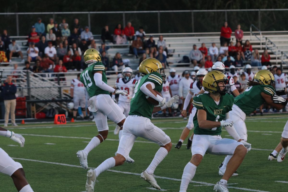 Henry Elser '26 returns a kick against Urbandale. The Trojans won their first home game on Sept. 9.