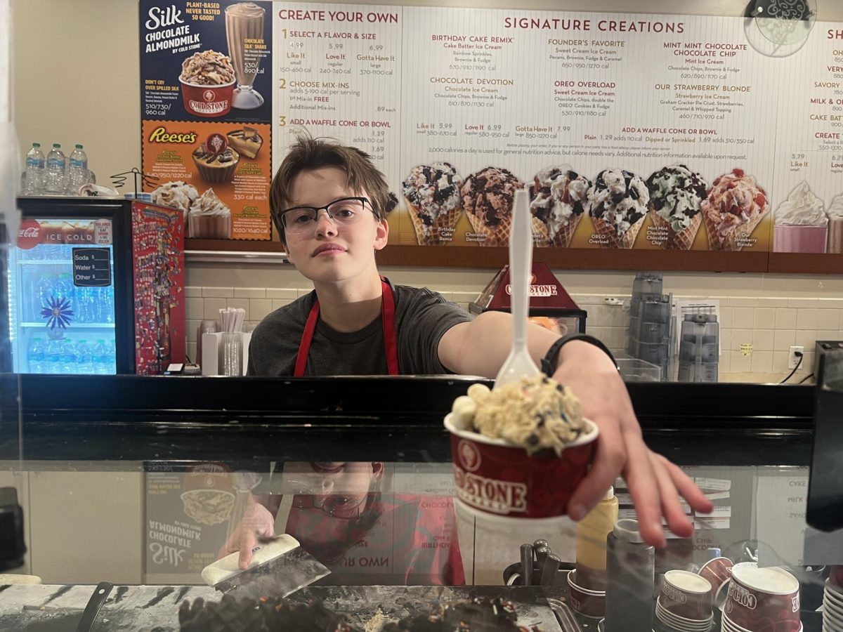 Aspen Herman '27 hands a customer ice cream.