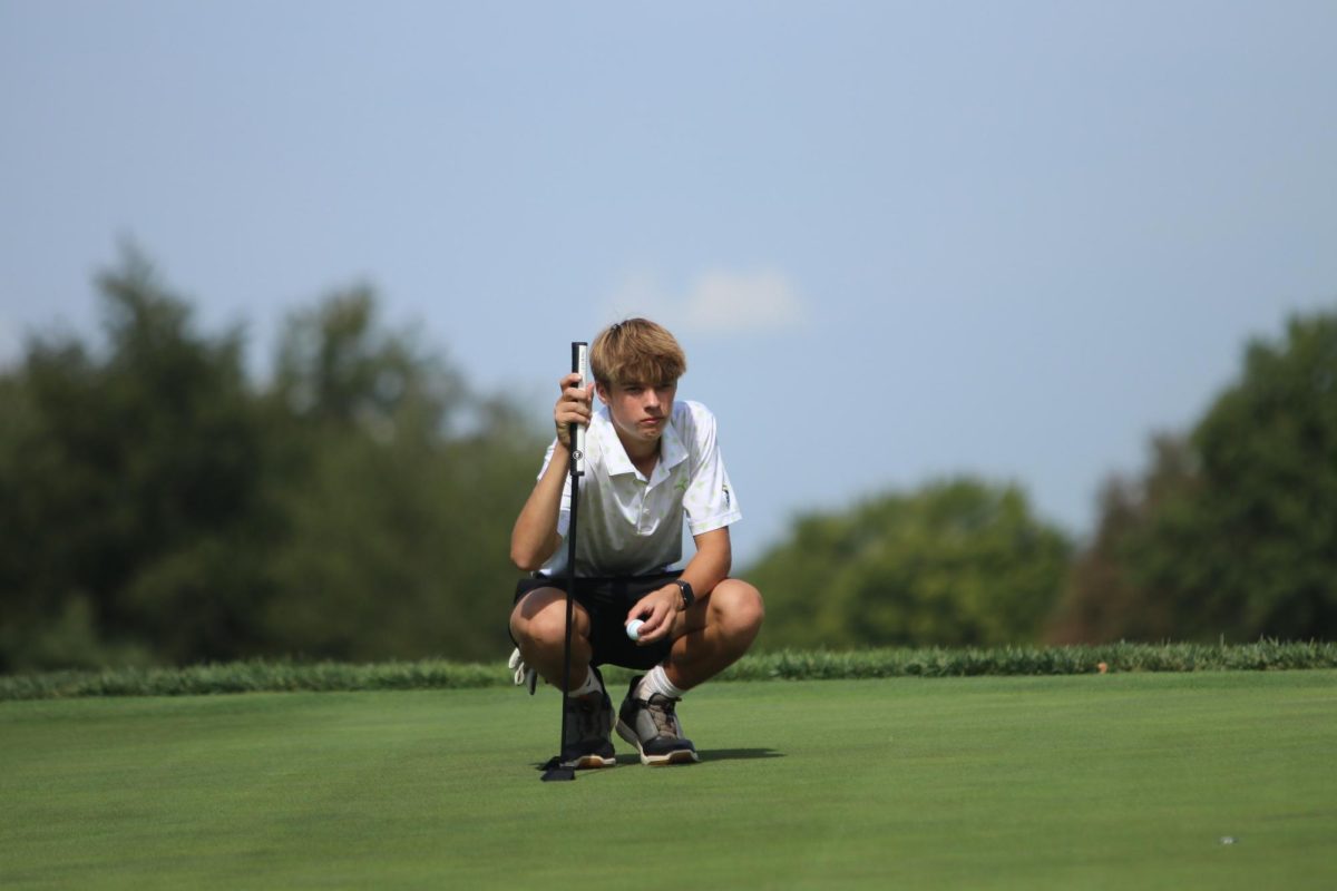 Tate Genkinger '26 scans the green on Sept. 16 at Finkbine Golf Course.