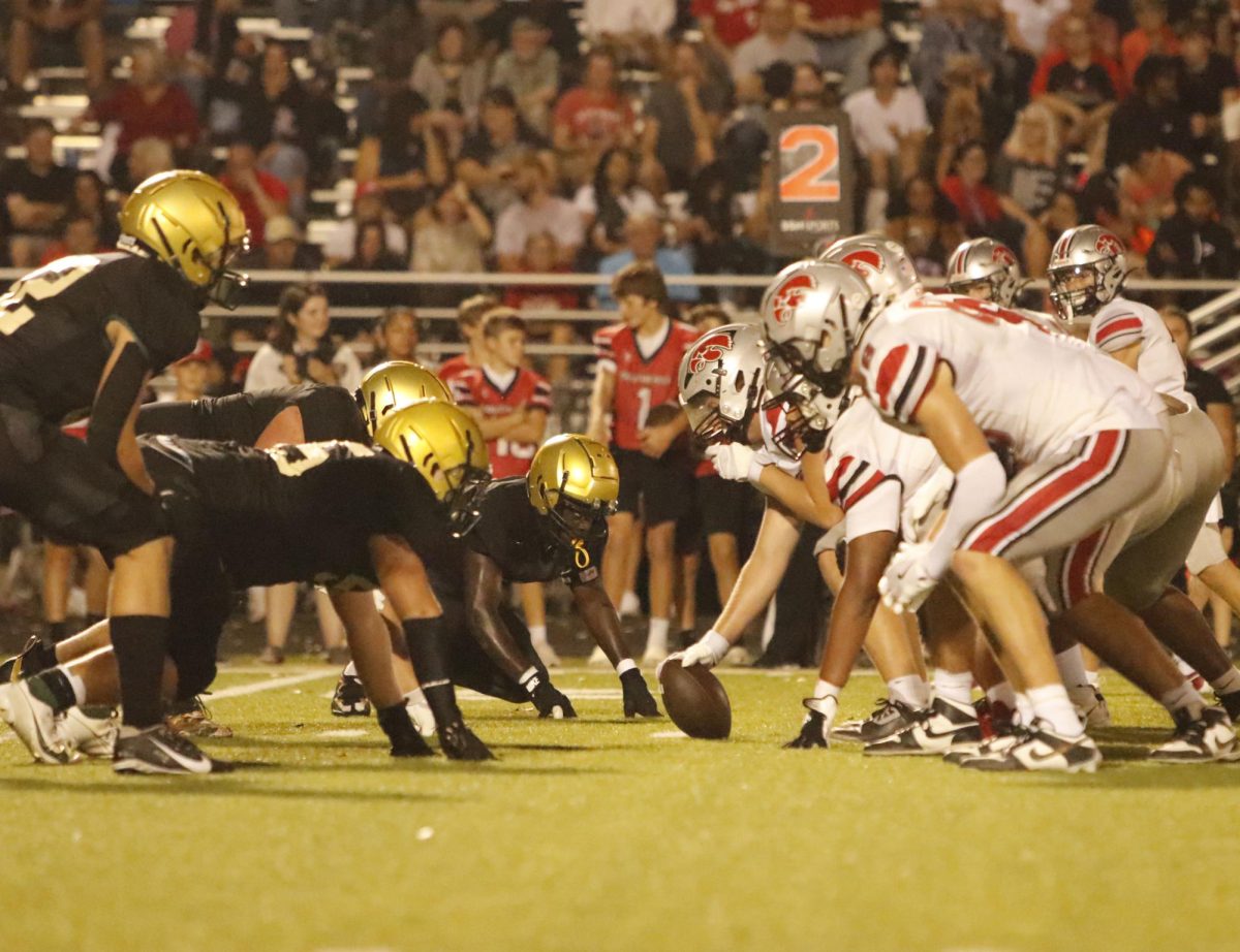 The Trojan football team gets ready as the Little Hawks take a field goal.