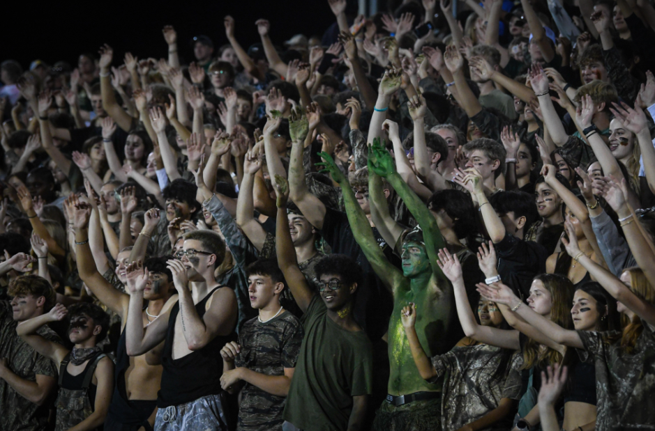 The West High student section waves their hands as the drumline performs during halftime.