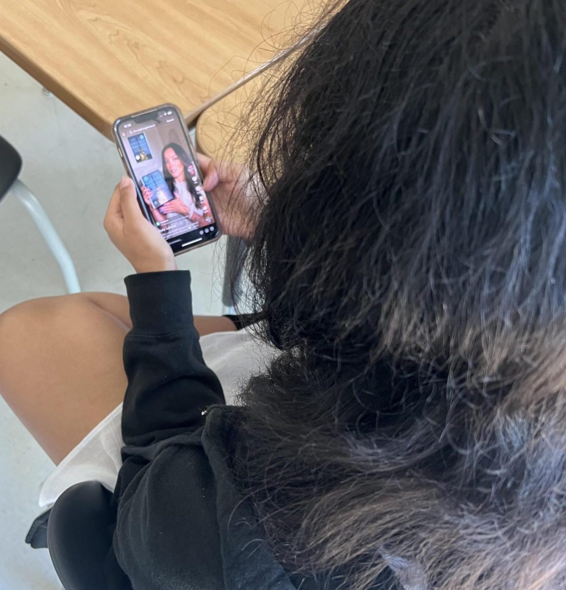 Nili Olalde '27 watches a TikTok video while looking for book recommendations.