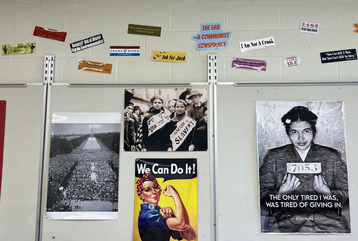 Posters with historical figures and slogans cover one of Caulk's classroom walls. 