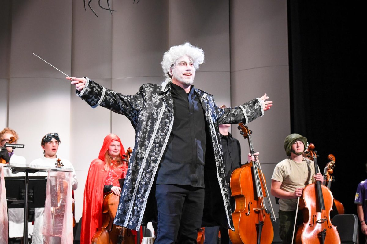 West orchestra director Jon Welch turns to the audience after the performance.