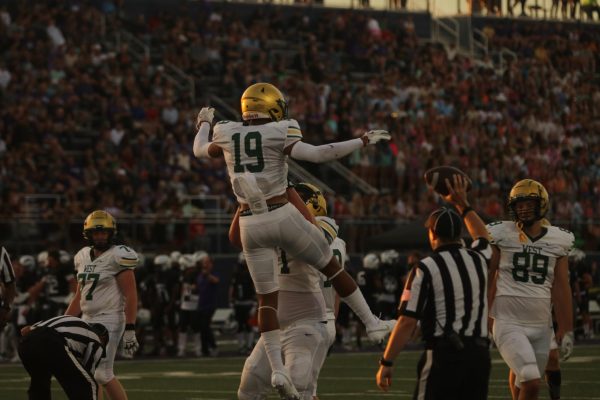 Colin Whitters '26 lifts up Mason Woods '25 after a touchdown versus Liberty on Aug 30. 