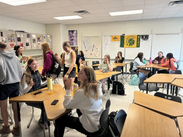 Club members enjoy a donut while talking to each other.