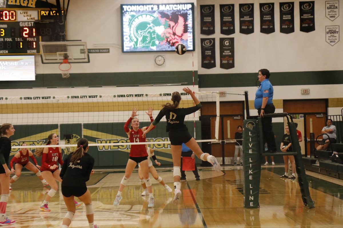 Audrey Small ’28 reaches up to slam the ball into City High's side of the court to earn a point for West.
