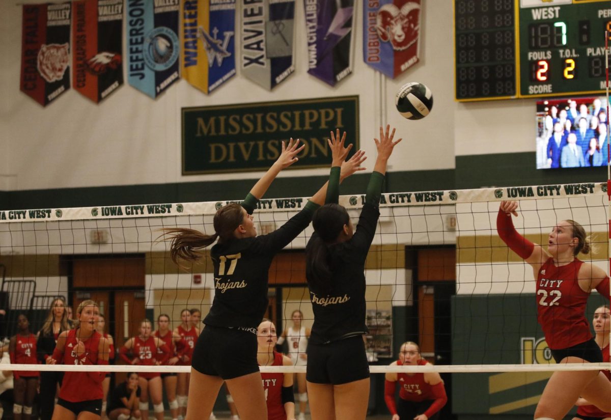 Number 17 Audrey Small ’28 and Gracie Liu ’27 jump up simultaneously to block a City High point. 