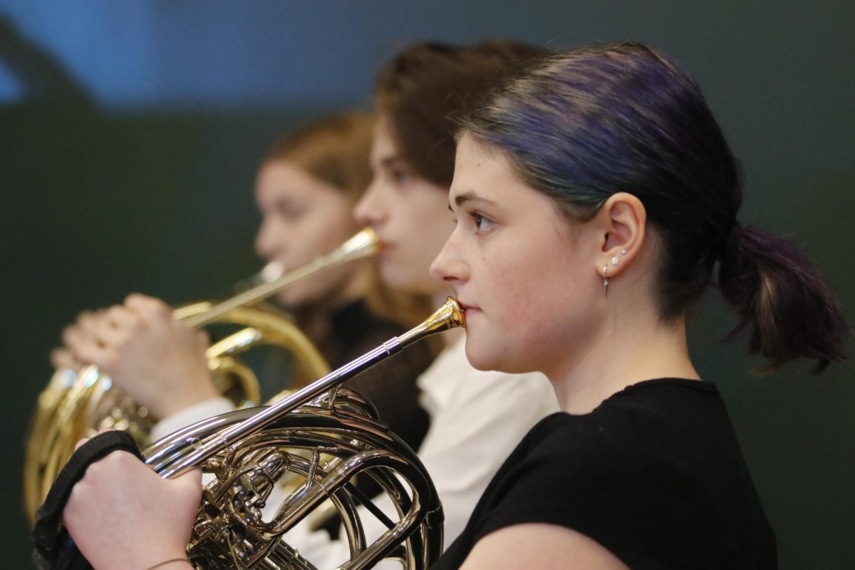 French horn player Isabel Ceynar '25 looks at conductor Ryan Middleton while performing "Serenade for Winds" by Antonín Dvořák.