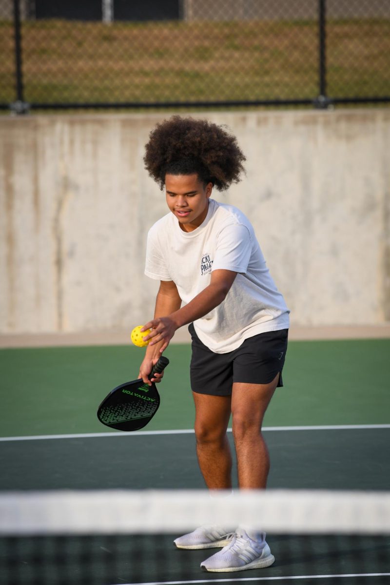Preparing to serve, Caled Medina '27 plays a match during the West High pickleball club's first tournament Sept. 27 at the West High tennis courts.