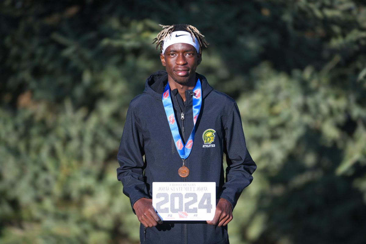 Moustafa "Moose" Tiea '25 poses with his medal and plaque after the awards ceremony. On Nov. 1, Tiea took ninth in the state meet, running 15:38.2 in Fort Dodge, IA.