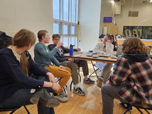 Donors River Small '26, Gabriel Conrad '26 and Tage Zimmerman '26 talk with volunteers Venelin Kotev '26 and Marie Stier '25 around the snack table. Volunteers gave donors water, juice and snacks while they rested after donating.