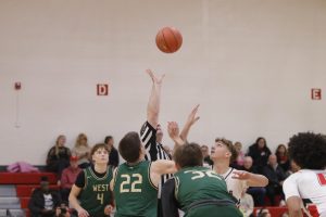 Jack McCaffery '25 attempts to gain possession of the ball as the referee throws it in the air.