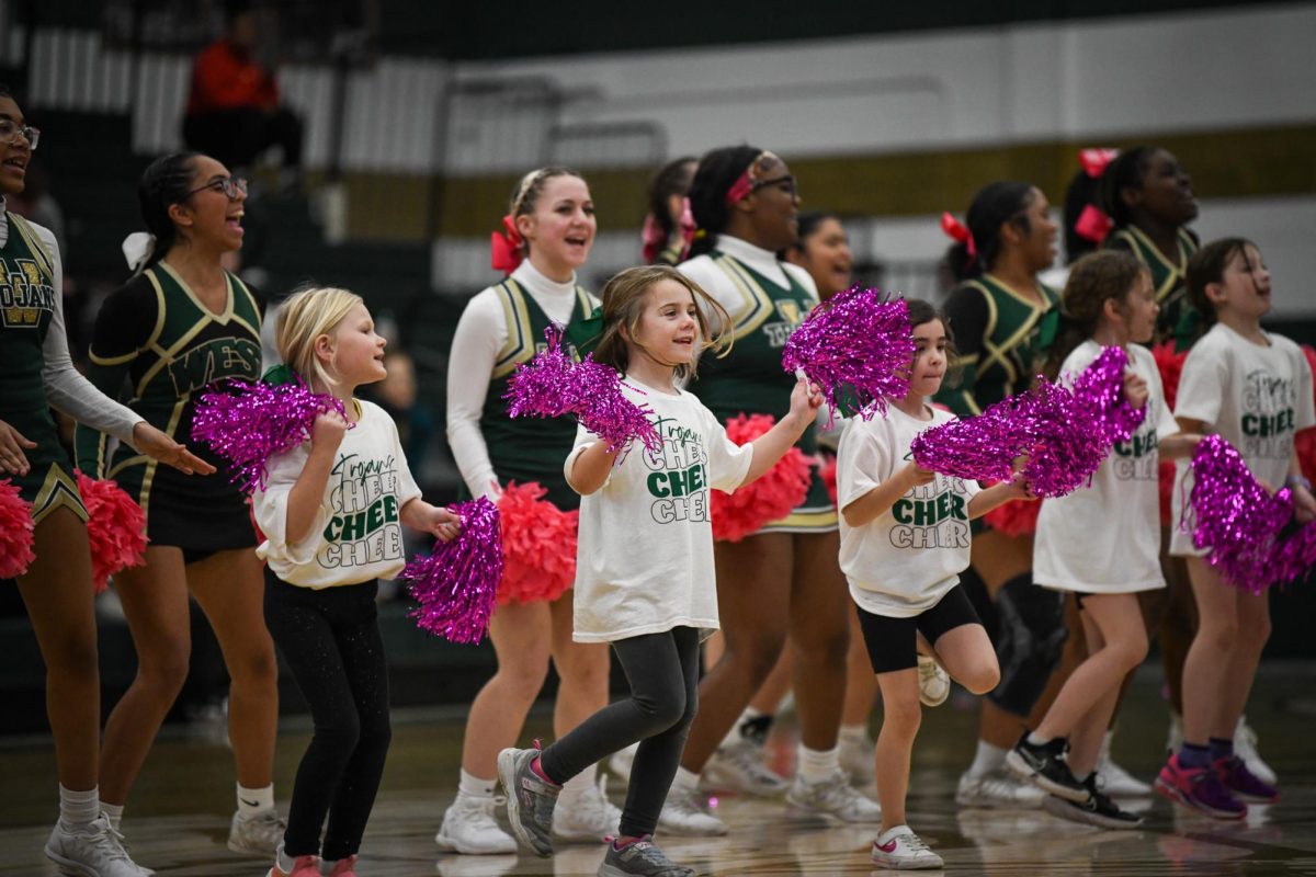Members of the cheer clinic perform their routine at halftime Jan. 17 in the North Gym. The clinic promoted cheerleading to younger students.