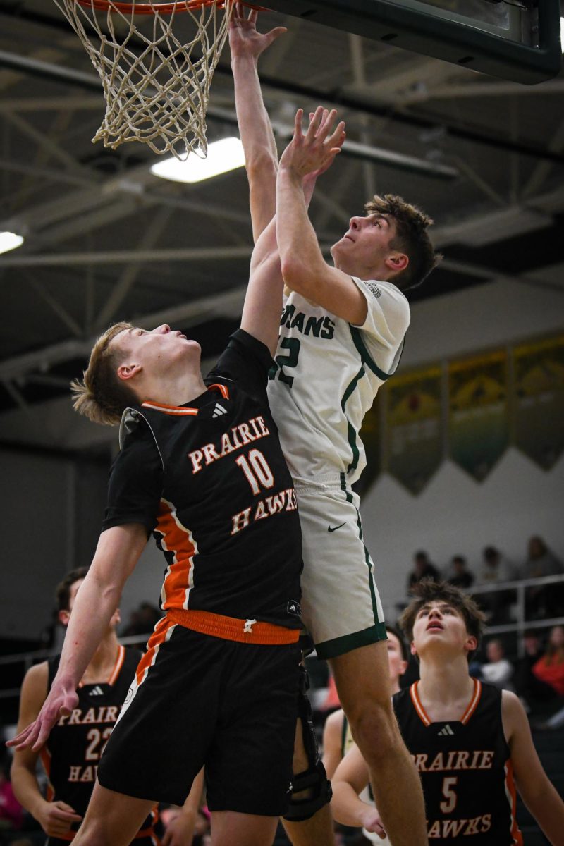 Jumping above a defender, Mason Goering '26 goes for a layup. On Jan. 17, Goering provided the most assists for the Trojans.